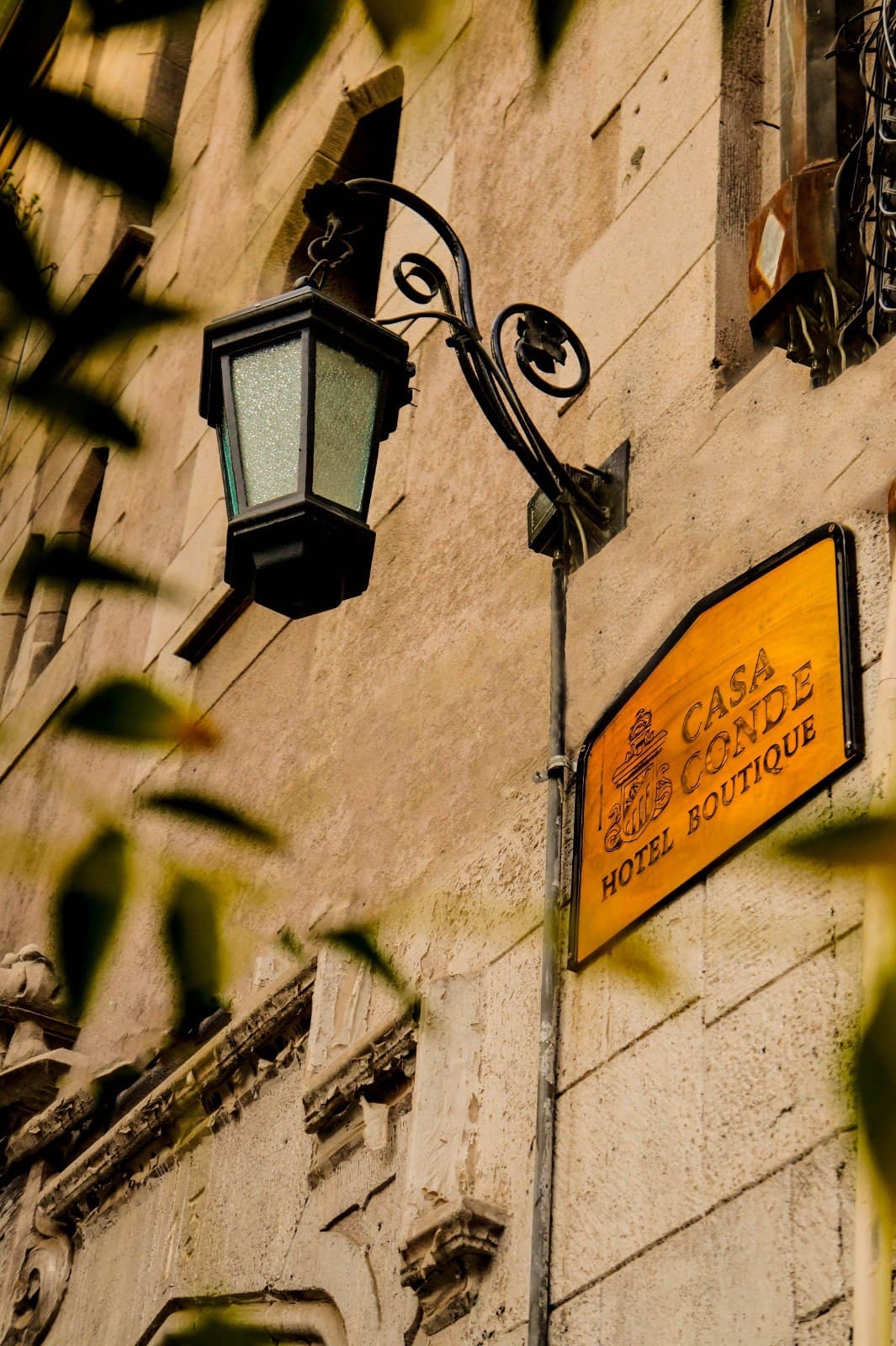 Wooden Casa Conde Hotel Boutique sign beside the street lantern