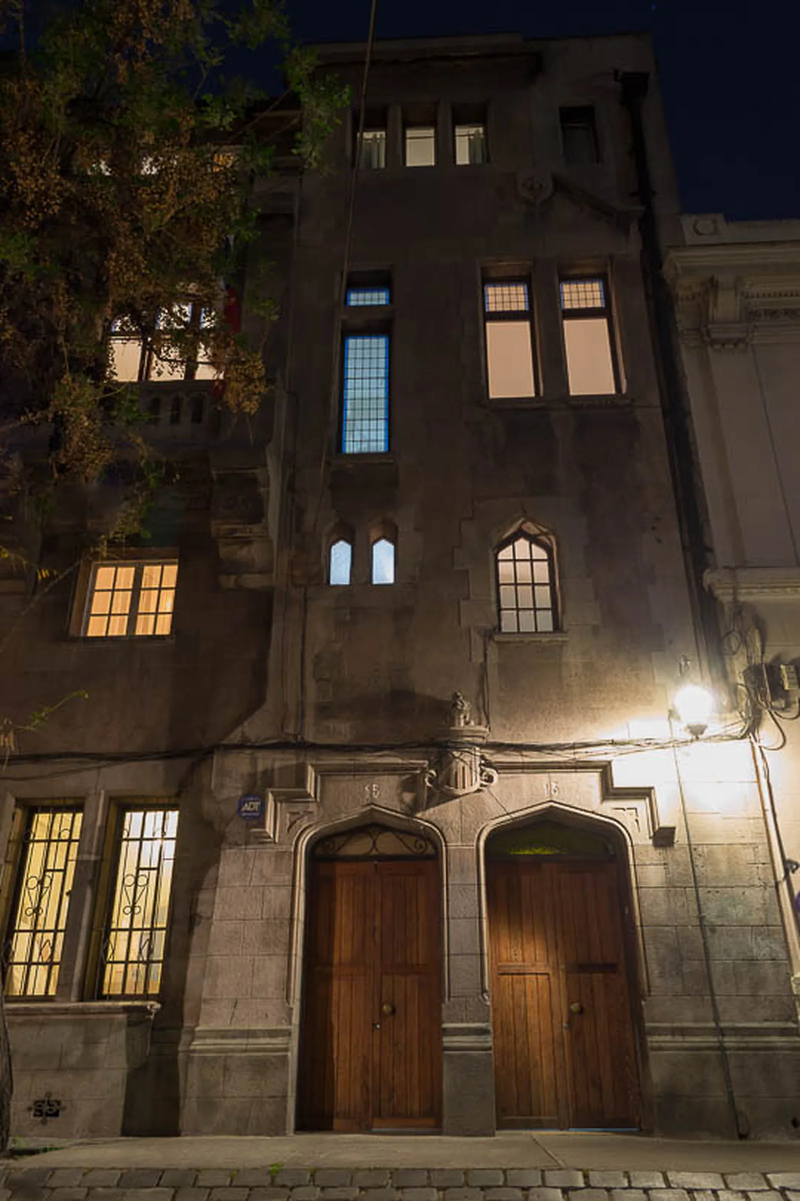 Fachada del edificio centenario de Casa Conde iluminada de noche, en el Barrio Concha y Toro